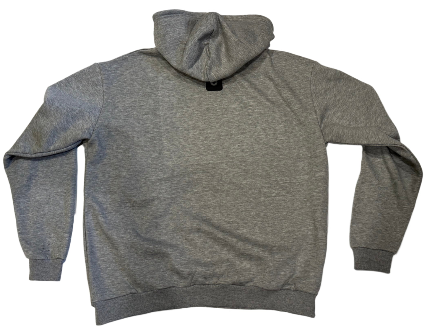 Gray hoodie on a white surface with a tiled floor background
